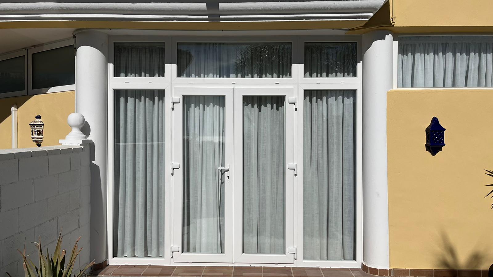 Puerta balconera de dos hojas practicables con apertura exterior y mosquitera plisada (2)